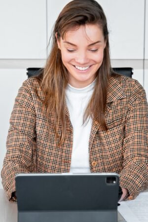 young woman smiles at her laptop